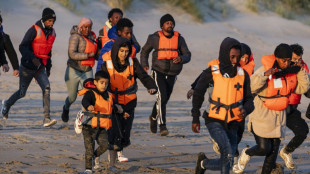 Inmigrantes con niños corren hacia abarrotadas barcas en el norte de Francia