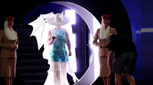 Osaka emerges for Melbourne opener under white hat and umbrella