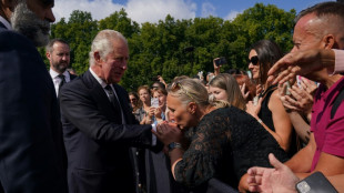 Kisses for King Charles III as he greets crowd at palace